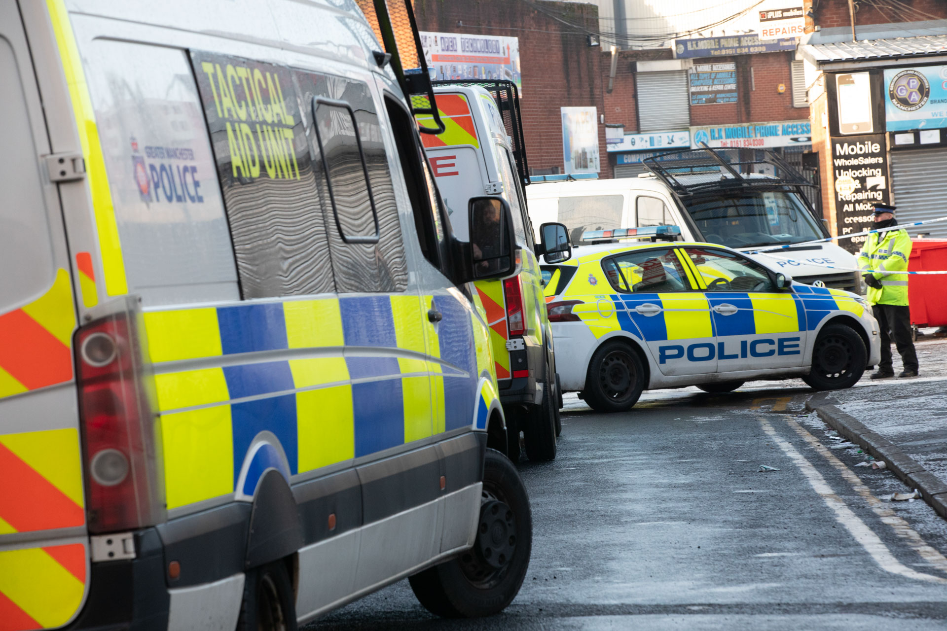 Image shows and Operation Vulcan raid with numerous police vans and police car in the shot.